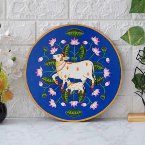 This beautiful pichwai painting features a mother cow and her calf nuzzling each other, surrounded by a vibrant array of flowers.